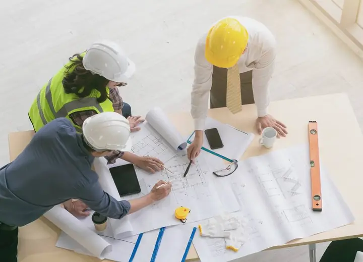 A project team reviewing construction drawings together